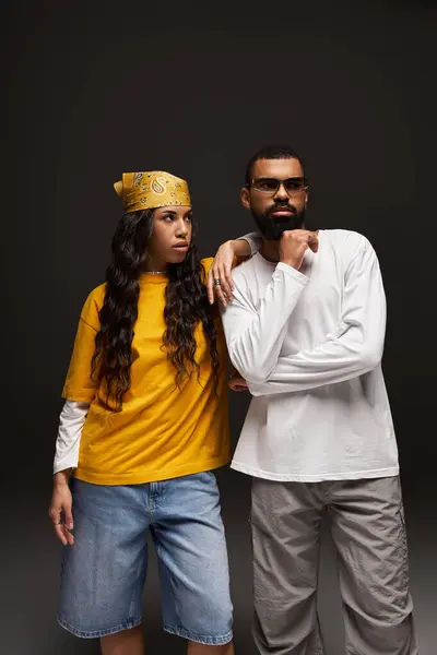 A stylish couple stands confidently in a creative studio, showcasing urban fashion with flair. — Stock Photo