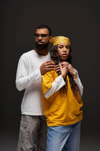 Un couple à la mode se tient ensemble, exsudant amour et charisme dans un studio bien éclairé. — Photo de stock