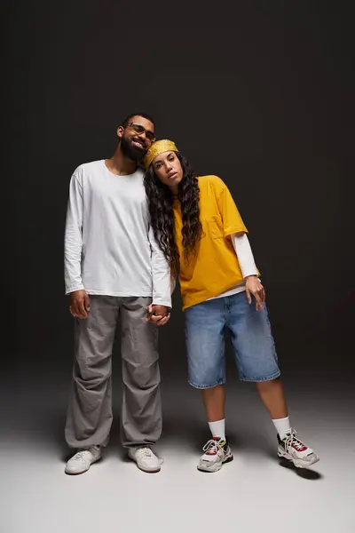 A fashionable couple holds hands while showcasing their unique style in a trendy indoor space. — Stock Photo