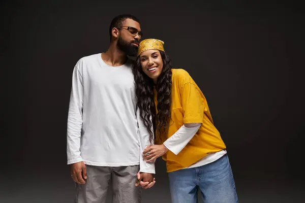 A stylish couple shares a joyful moment, expressing love through their fashionable outfits. — Stock Photo