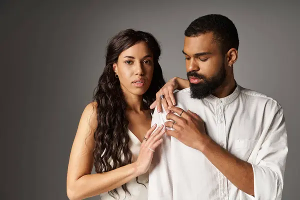 A fashionable couple conveys deep affection, dressed elegantly in a minimalist backdrop. — Stock Photo