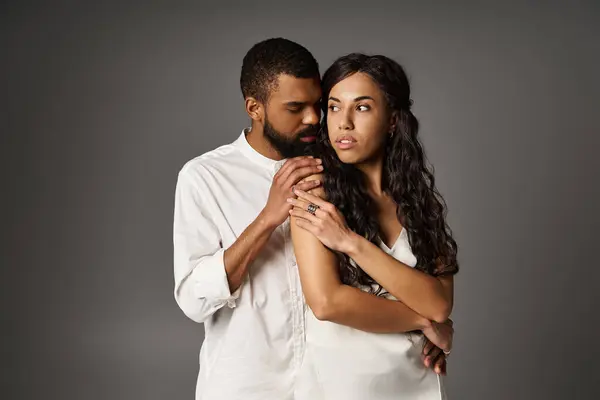 A fashionable couple expresses love through an intimate moment captured in a creative studio. — Stock Photo