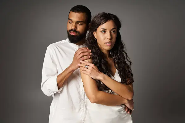 Un couple à la mode partage un moment d'intimité, avec l'homme embrassant doucement la femme. — Photo de stock