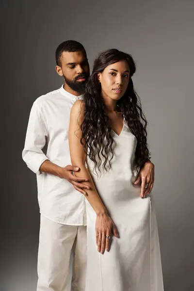 Una pareja de moda se encuentra de cerca, exudando amor y conexión en sus elegantes trajes. - foto de stock