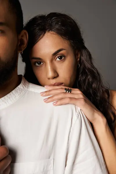 Couple rayonne d'amour et d'élégance tout en posant étroitement sur un fond neutre. — Photo de stock