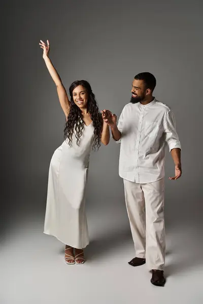 A fashionable couple enjoys a joyful dance while showcasing their love and style together. — Stock Photo