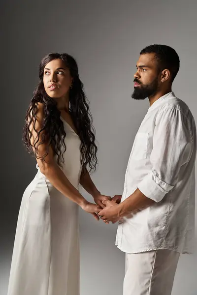 A couple exudes elegance, connecting through a tender gaze in a modern, artistic environment. — Stock Photo