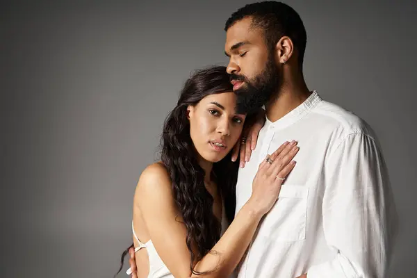 A fashion forward couple stands close, sharing an intimate moment in a contemporary space. — Stock Photo