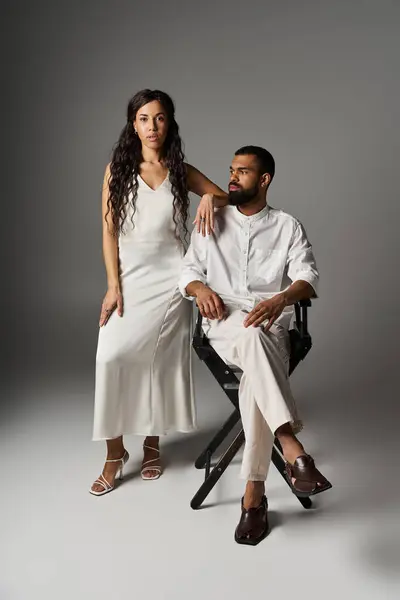Man and woman showcase their fashion sense while sitting in a studio setting filled with romance. — Stock Photo