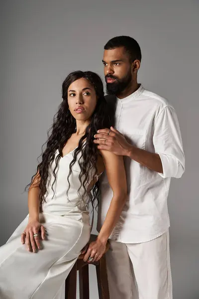 Elegant man and woman pose together in a minimalist studio, showcasing their fashion sense and love. — Stock Photo