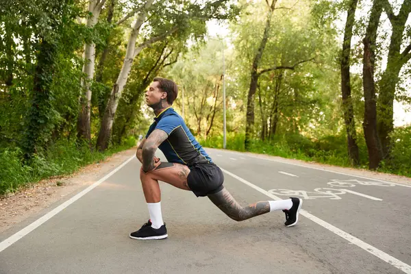 Handsome young man taking a stroll along a tranquil pathway surrounded by lush greenery. — Stock Photo