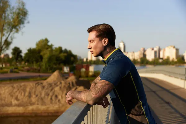 A handsome young man strolls along a riverside path, appreciating the tranquil evening glow. — Stock Photo