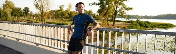 A young man strolls along a scenic bridge, taking in the beauty of nature and reflections. — Stock Photo