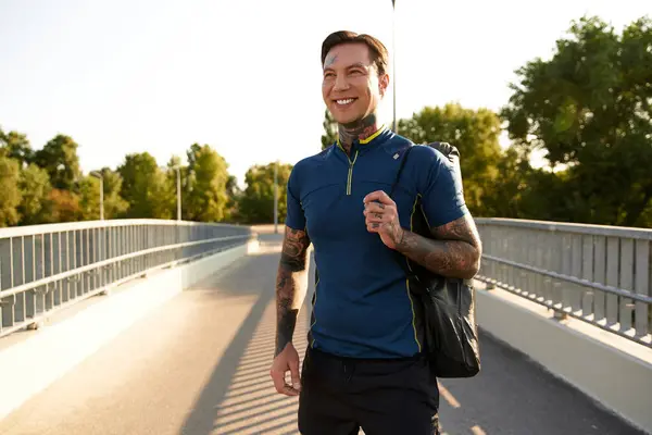 A young man walks confidently along a serene path, smiling and embracing the warm sunlight. — Stock Photo