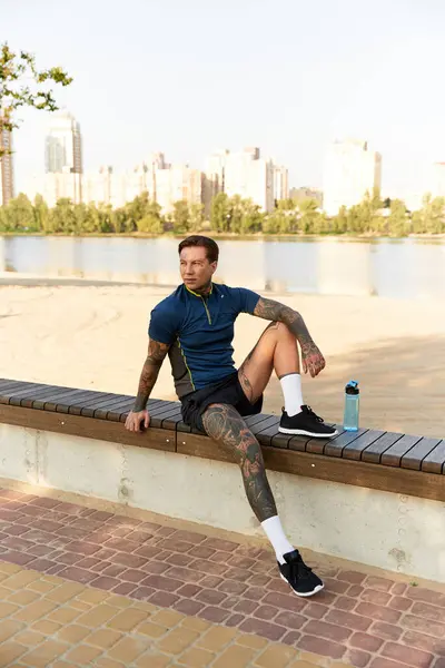 A young man sits by the river, reflecting on his surroundings in the afternoon sun. — Stock Photo