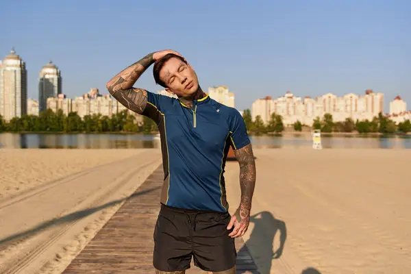 A handsome young man takes a moment to stretch on a scenic beach boardwalk under clear skies. — Stock Photo