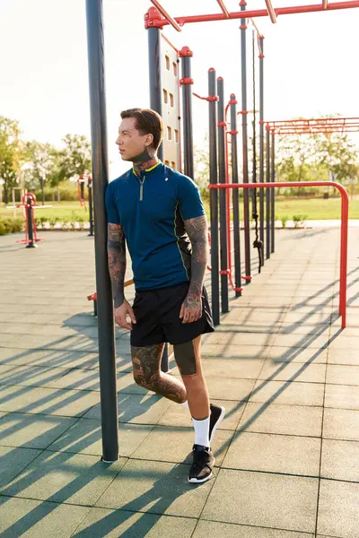 Handsome young man strolls through a vibrant park, enjoying the warm sunlight and surroundings. — Stock Photo