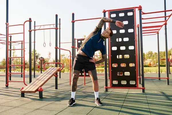 Young man enjoys a peaceful moment while stretching in a colorful park near sunset. — Stock Photo