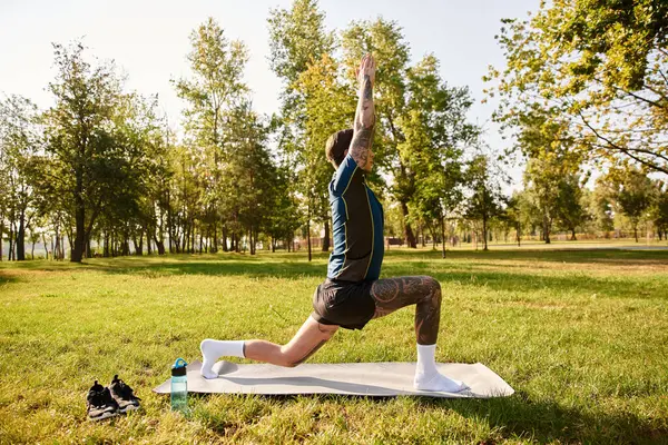 Handsome young man stretches in a serene park, enjoying a peaceful moment in nature. — Stock Photo