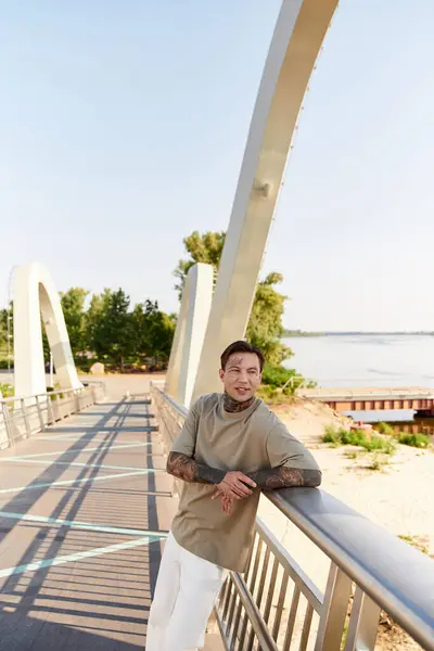 A young man strolls along a peaceful riverside pathway, basking in the warm sunlight. — Stock Photo