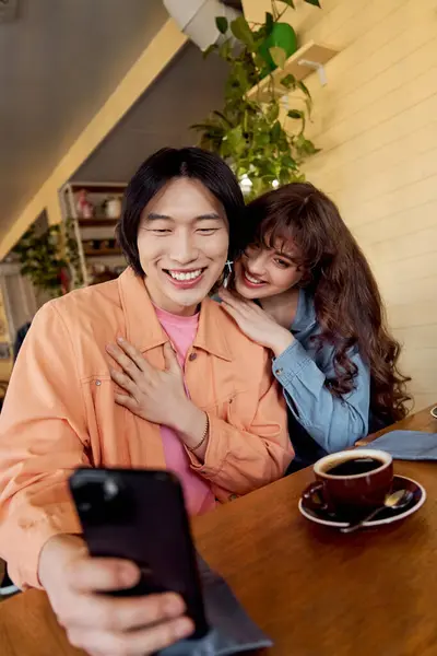Multicultural friends capture a blissful moment while sharing laughter in a cafe. — Stock Photo