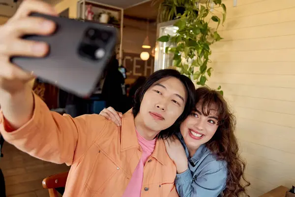 Two friends enjoy each other's company in a cheerful cafe while taking a fun selfie together. — Stock Photo