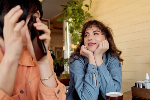Jovens amigos desfrutam de um momento quente juntos em um café vibrante cheio de risos e conversas. — Fotografia de Stock
