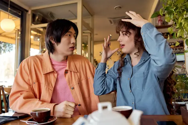 Dois jovens amigos compartilham uma alegre troca de café em um café vibrante, celebrando a diversidade. — Fotografia de Stock