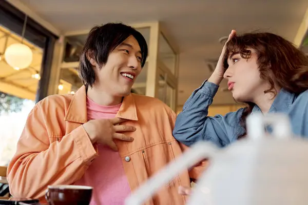 Two friends of different cultures enjoy a joyful chat at a vibrant cafe. — Stock Photo