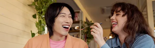 Two friends share laughter and food in a vibrant cafe, enjoying a moment of blissful connection, banner — Stock Photo