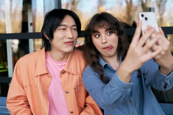Two friends capture joyful memories while posing for a selfie in a vibrant cafe setting. — Stock Photo