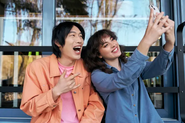 Two multicultural friends enjoy a blissful moment while taking selfies at their favorite cafe. — Stock Photo