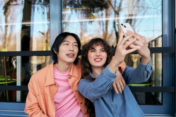 Two young friends share a happy moment while taking a selfie in a welcoming cafe. — Stock Photo