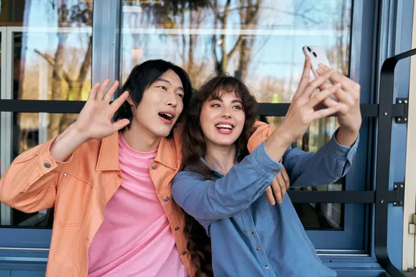 Cheerful young friends share a joyful moment taking selfies together in a lively cafe. — Stock Photo
