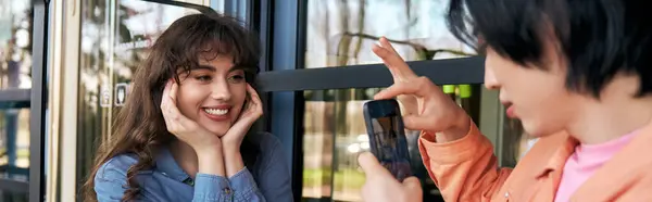Dos amigos multiculturales disfrutan tomando fotos en un acogedor café, compartiendo risas, pancartas - foto de stock