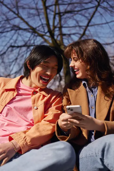 Two multicultural friends laughing and enjoying each others company. — Stock Photo