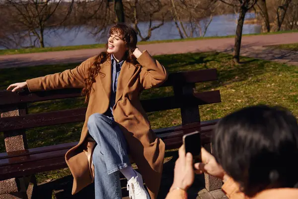 Two multicultural friends share laughter, capturing a joyful moment in the park under the sun. — Stock Photo