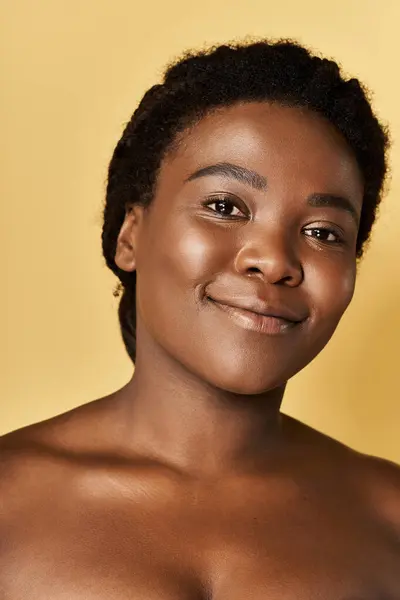 Jeune femme afro-américaine met en valeur son éclat naturel de peau dans une atmosphère de studio dynamique. — Photo de stock