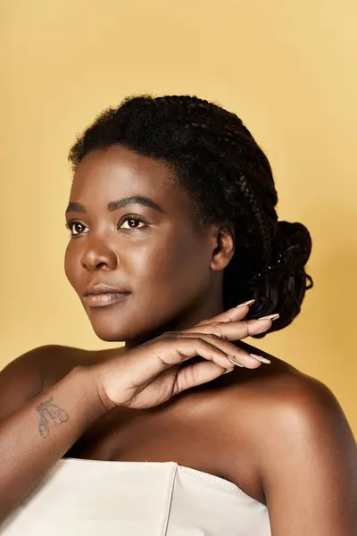 Una giovane donna afroamericana mette in mostra la sua pelle radiosa e la sua bellezza in un ambiente caldo da studio. — Foto stock