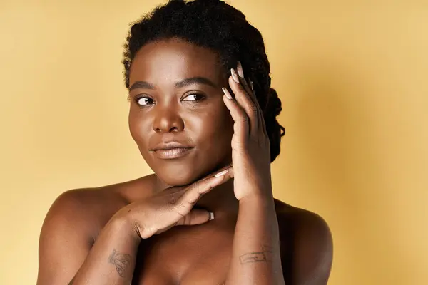 Questa giovane donna afroamericana mostra la sua pelle radiosa mentre posa con grazia in uno studio. — Foto stock