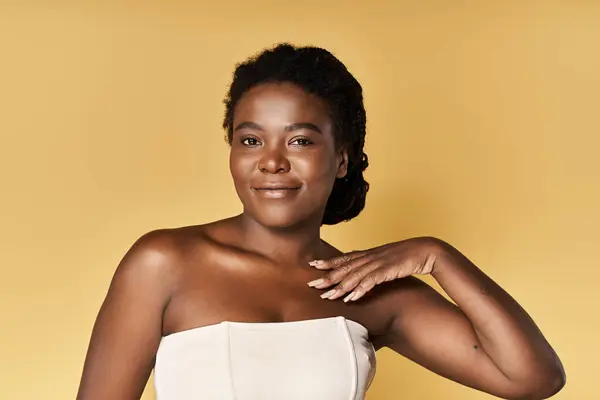 A young African American woman showcases her radiant skin and beauty in a vibrant studio setting. — Stock Photo