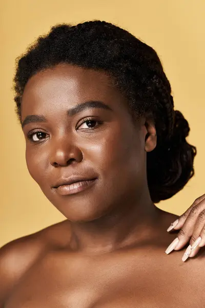 Eine junge Afroamerikanerin zeigt in einem hellen Atelier strahlende Haut und verkörpert Schönheit. — Stockfoto