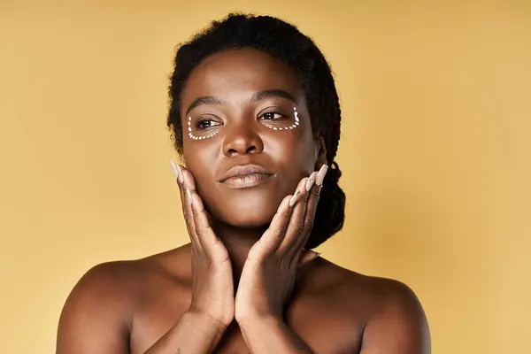 Young African American woman showcases radiant skin while framed by a warm backdrop. — Stock Photo