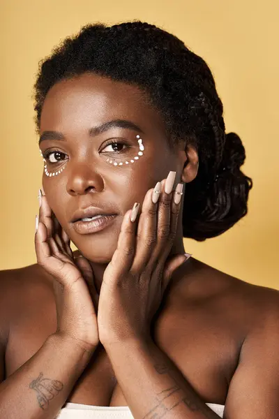 A young african american woman showcases radiant skin and beauty in a studio setting. — Stock Photo