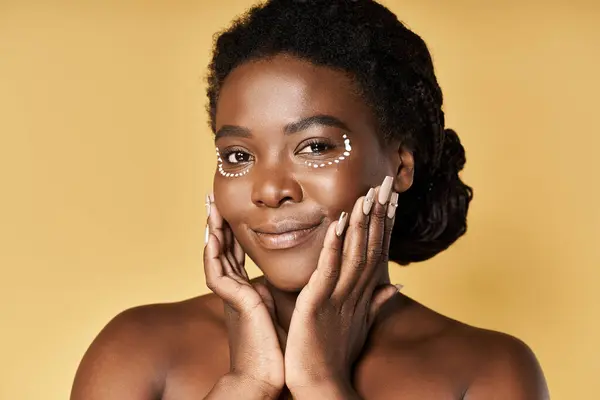A young Black woman shines with confidence in a bright studio, showcasing her stunning look. — Stock Photo