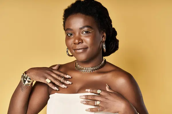Eine junge Afroamerikanerin präsentiert ihre strahlende Haut in einem hellen Studio und umarmt die Schönheit. — Stockfoto