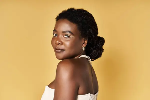 A young woman with glowing skin showcases beauty in a bright studio, radiating confidence. — Stock Photo
