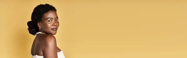 A confident young woman displays her radiant skin in a vibrant studio setting, banner — Stock Photo