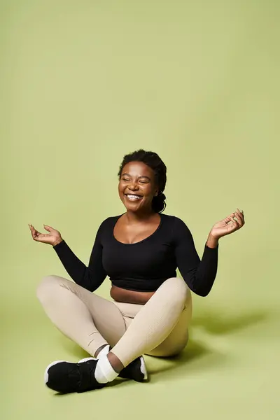 In a bright studio, a young african american woman enjoys an energetic fitness session. — Stock Photo