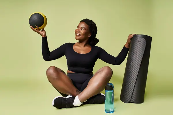 A young fit African American sportswoman happily engages in a workout session using equipment. — Stock Photo